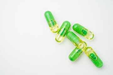 transparent pills with a mixture of green powder and oil, Food supplements, vitamins and minerals