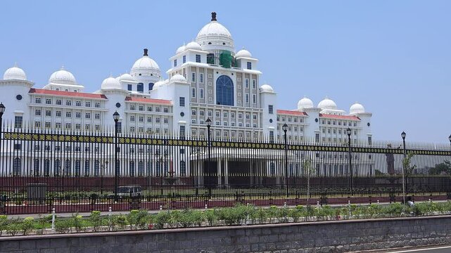 View of road traffic near Dr. B.R. Ambedkar Telangana State Secretariat building in sunny day. Hyderabad, India.