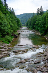 stones and mountain river with small waterfall, blurred background