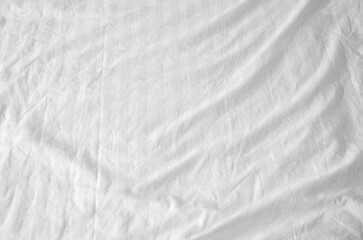 Top view of wrinkles on an unmade bed sheet after waking up in the morning.
