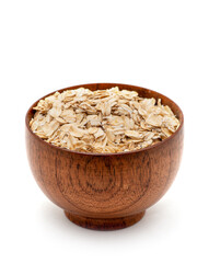 Oats spilling from wooden bowl.