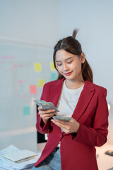 Young businesswoman happily counts money in her office, surrounded by corporate elements, reflecting achievement and financial success