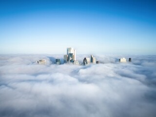 Elevated view of the skyline at the City of London, England, with only the tops o the skyscrapers peaking out of the clouds and fog