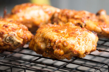 Roasting Chicken on grill rack by charcoal stove in Thai local kitchen selective focus  close up
