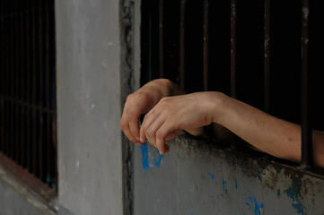 close up of prisoner hands in jail background.