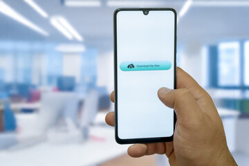 Close-up of “Download” message on smartphone screen. Online file download concept. Office background. Download message. 
