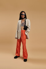 Fototapeta premium A young woman exudes confidence in a trendy ensemble, showcasing her unique style.