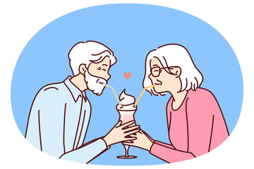 Elderly romantic couple drinking cocktail from straws together enjoying retirement and dating on eve of february 14th Valentine day. Romantic grandparents show love between elderly