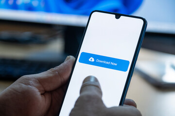 Close-up of “Download” message on smartphone screen. Online file download concept. Office background. Download message. 