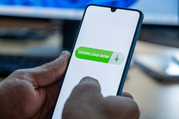 Close-up of “Download” message on smartphone screen. Online file download concept. Office background. Download message. 