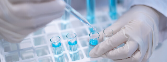 Scientist pipette doppler blue liquid in test tube beaker laboratory science biotechnology biology...