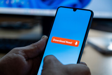 Close-up of “Download” message on smartphone screen. Online file download concept. Office background. Download message. 