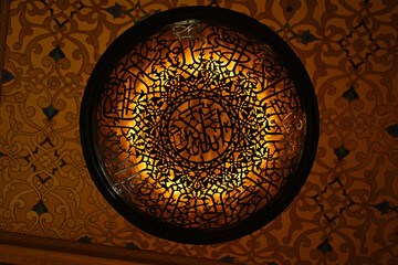 A unique round chandelier with Arabic patterns inside Katara Mosque, located within the Katara Cultural Village, a cultural and commercial hub in Doha, Qatar.