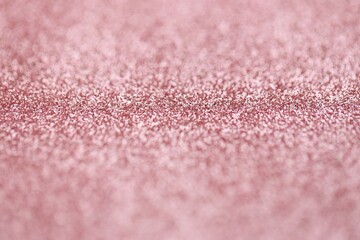 Beautiful pink glitter sparks texture as background with shallow depth of field