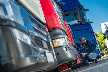 A Truck DriverExamines Large Vehicles at a Transportation Event During a Sunny Afternoon
