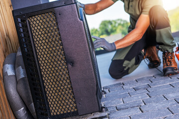 Technician Repairing an Air Conditioning Unit Outside a Residential Building on a Sunny Day