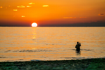 A single man taking selfie in the Mediterranean Sea at sunset