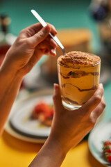 Hands holding a tiramisu cup