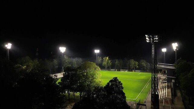 Video of renovated stadium of FC Zeleznicar at evening with reflectors shining. Empty soccer field at night. Pancevo, Serbia 21.10.2024