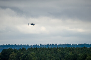 British army Boeing Apache Attack helicopter gunship AH2 AH64E AH-64E ArmyAirCorp in low level flight over countryside