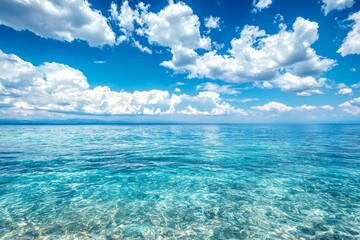 Obraz premium A serene scene of the clear blue sky and turquoise ocean, with fluffy white clouds in the background. The water is crystal clear, reflecting the vibrant colors of the sky above it. 