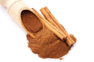 Cinnamon powder in scoop and sticks isolated on white background
