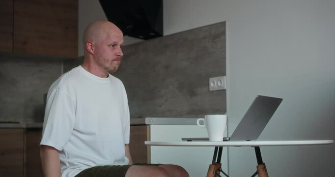 A millennial freelancer man works at a computer and gets comments on his project. A disgruntled millennial man gets angry and swears while looking at the laptop screen. Online casino. High quality 4k