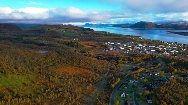 Aerial shot of the small town of Sortland in Northern Norway on a partly sunny day during autumn with mountains in the background.