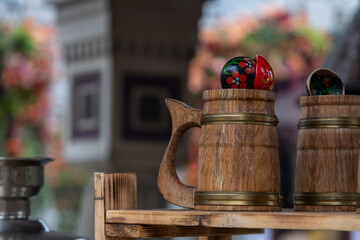 Close-up side view with big wooden mugs and wooden spoons standing on shelf. Soft focus. Copy space. Reusable natural organic kitchen cutlery theme.