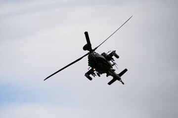 close-up of a British army Boeing Apache Attack helicopter gunship AH64E AH-64E ArmyAirCorp banking hard in low level overhead flight