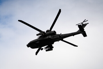 Fototapeta premium close-up of a British army Boeing Apache Attack helicopter gunship AH64E AH-64E ArmyAirCorp banking hard in low level overhead flight