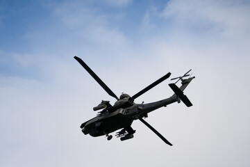 close-up of a British army Boeing Apache Attack helicopter gunship AH64E AH-64E ArmyAirCorp banking hard in low level overhead flight