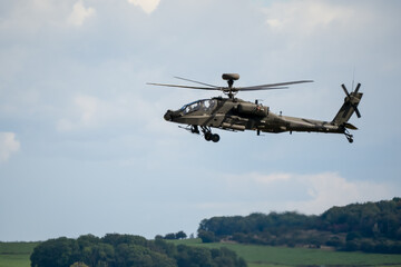 close-up side view of a British army Boeing Apache Attack helicopter gunship AH64E AH-64E ArmyAirCorp in low level flight