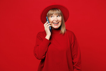 Elderly blonde woman 50s years old wear sweater hat casual clothes talk speak on mobile cell phone...