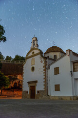imagen nocturna de la Ermita de Flix, con el cielo estrellado, mostrando una ermita oculta entre las rocas