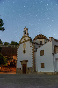 imagen nocturna de la Ermita de Flix, con el cielo estrellado, mostrando una ermita oculta entre las rocas