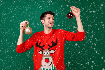 Photo portrait man wearing funny sweater hanging xmas balls isolated green color background