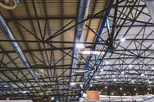 The ceiling of an industrial hangar illuminated by fluorescent lamps.