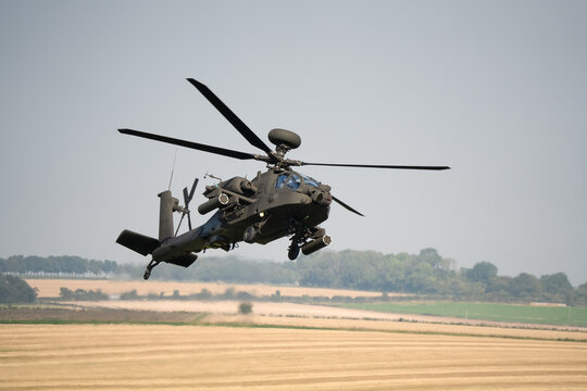 close-up front-quarter view of a British army Boeing Apache Longbow Attack helicopter gunship AH64E AH-64E AH2 ArmyAirCorp in low level banking flight