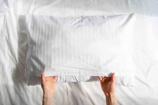 Woman change pillowcase and bedsheets in hotel bedroom, laundry day