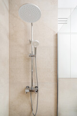 Modern shower fixture with overhead and handheld options in a sleek bathroom setting
