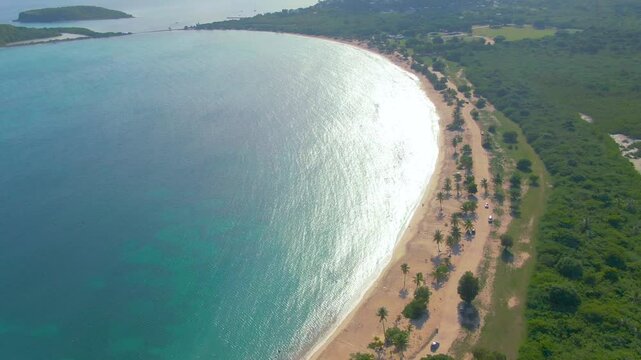 Sun Bay Beach, Vieques, Puerto Rico - A Scenic View of the Beach Reveals Golden Sand, Clear Turquoise Waters, and Lush Palm Trees Along the Shore - Aerial Drone Shot