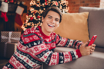 Photo of attractive funny guy wear print jumper celebrating xmas texting instagram twitter telegram...