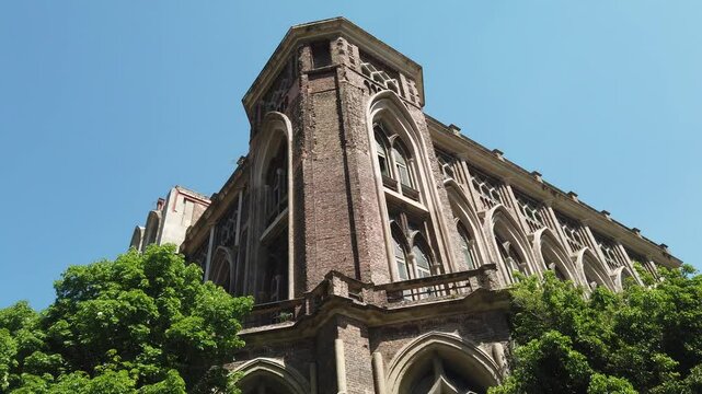 Low angle details of neo gothic architecture Facade Engineering University Building in Buenos Aires, Urban Park Setting at Daylight