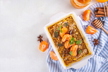 Tangerine or orange Creamsicle Baked Oatmeal, sweet healthy dessert with oats, fresh ripe tangerines and oranges, with creamsicle topping, honey and spices