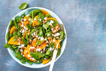 Sweet, savory delicious Persimmon autumn Salad with baby spinach leaves, cottage cheese and...
