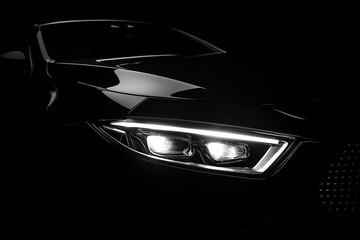Luxury car headlight on black background. Close up, copy space