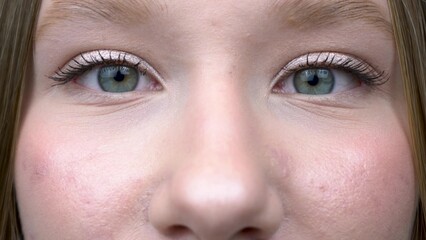 Obraz premium Close-up of a girl opening and closing her blue eyes.