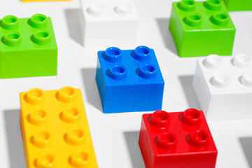 Naklejka premium Close up of many plastic colored pattern rainbow toy brick blocks for building constructions on white isolated background. The concept of children’s educational games. Image for your design