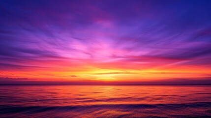 Obraz premium Vibrant sunset over the ocean with colorful clouds.